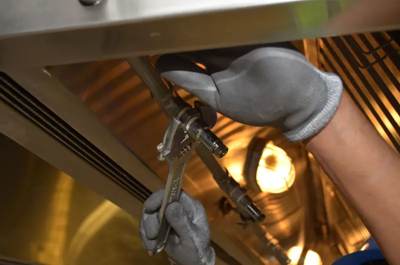 A wrench tightening the fitting on a gas supply pipe