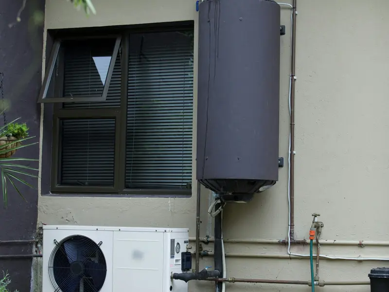A geyser and heat pump fitted against the outside wall of a South African house
