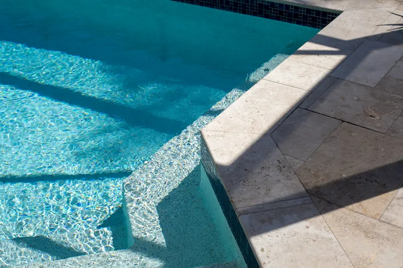 Pool steps and tiled coping at the shallow end of a swimming pool