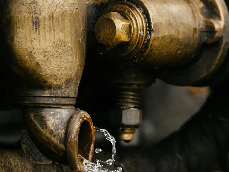 Water spraying from an old brass valve on a supply pipe